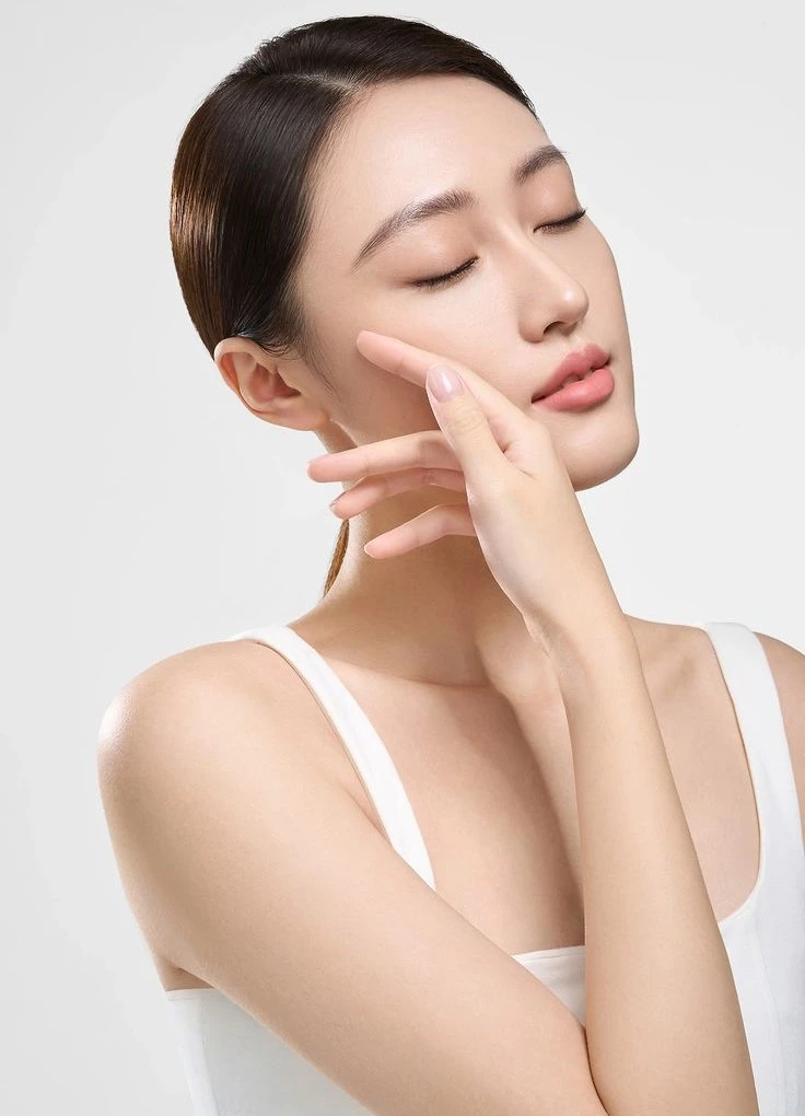 Asian woman with her hand resting against her cheek